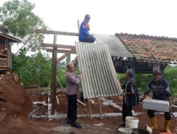 Anggota Polisi Caket Aipda Tono membantu pembangunan rumah seorang warga